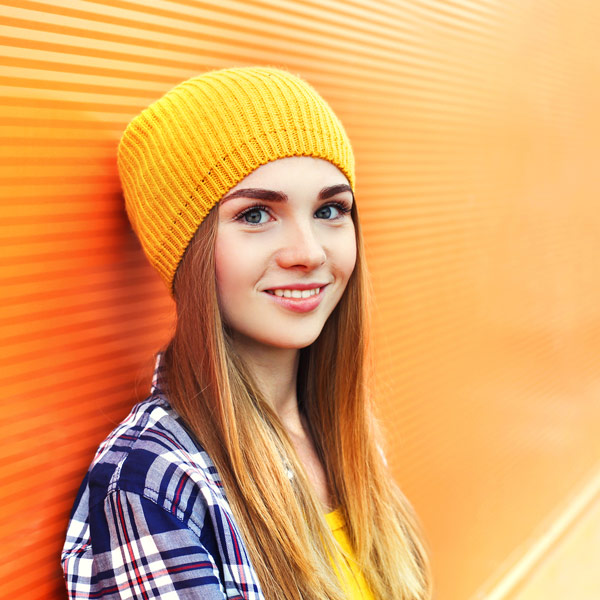 young woman against orange wall