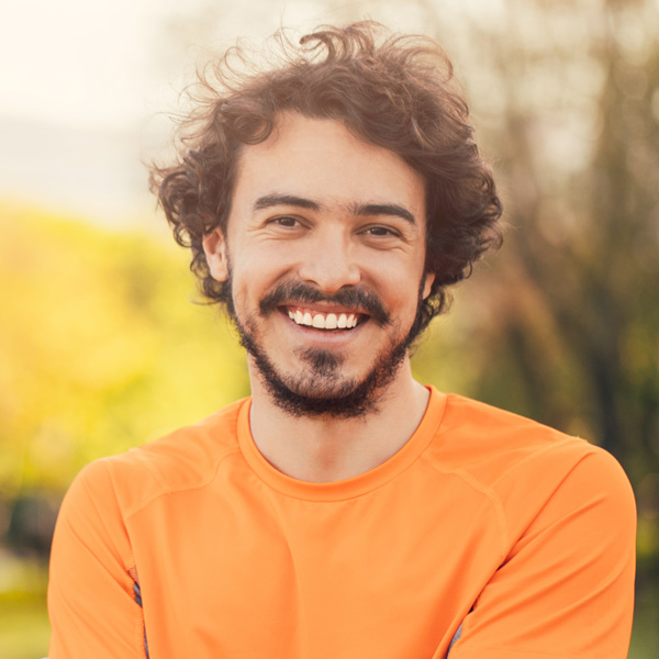young man in orange shirt outdoors